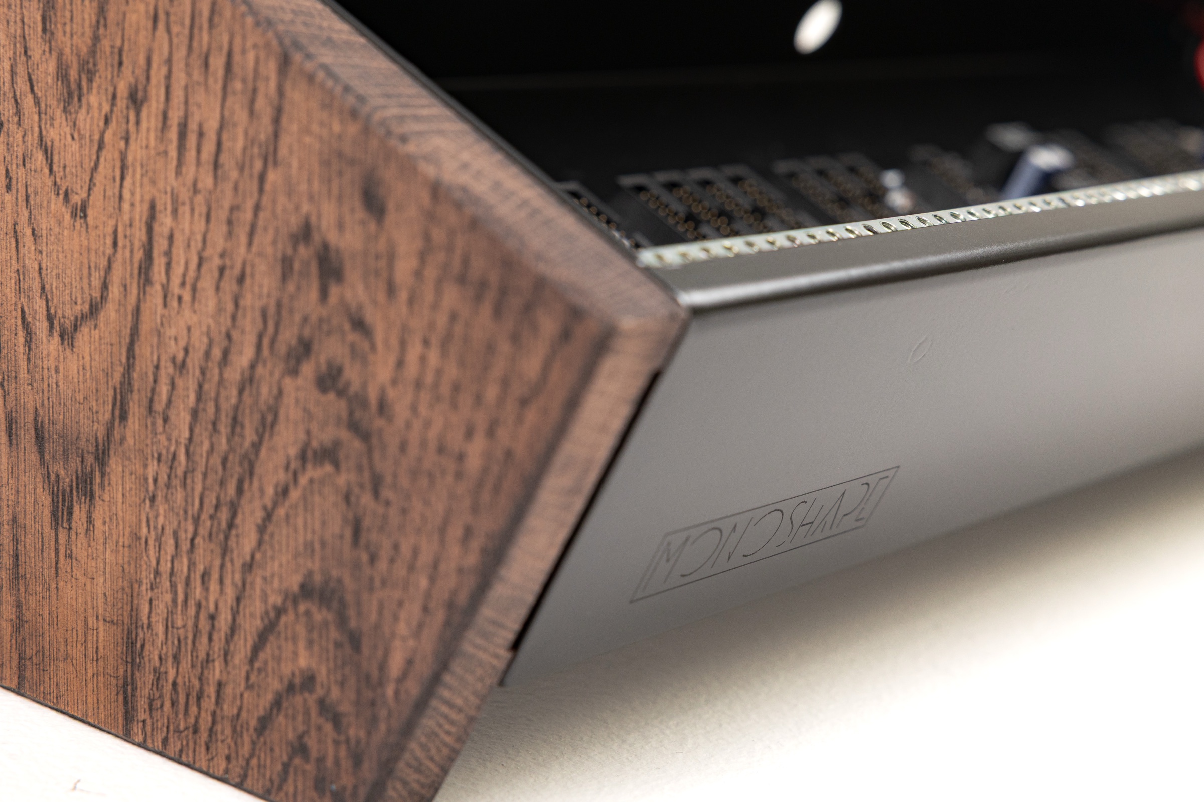 Oak side panel meeting the metal chassis of a MONOSHAPE Eurorack case